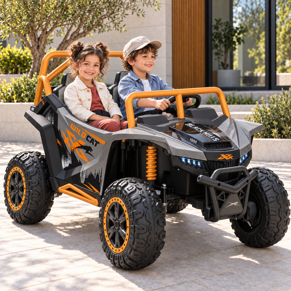 Gray Arctic Cat XL 24V 4WD Kids Ride-On UTV, Two Seater Lifestyle Photo of Two Kids Driving on a Driveway