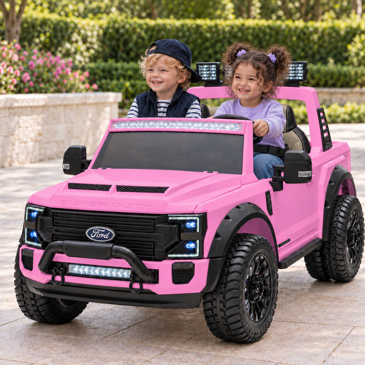 Pink Ford F450 Custom Edition 24V Kids Ride-On Truck, Two Seat Lifestyle Photo of Two Toddlers Driving