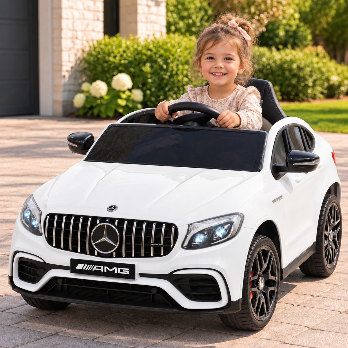 White Mercedes AMG GLC 63S 12V 4WD Kids Ride-On Car, Girl Driving on a Driveway