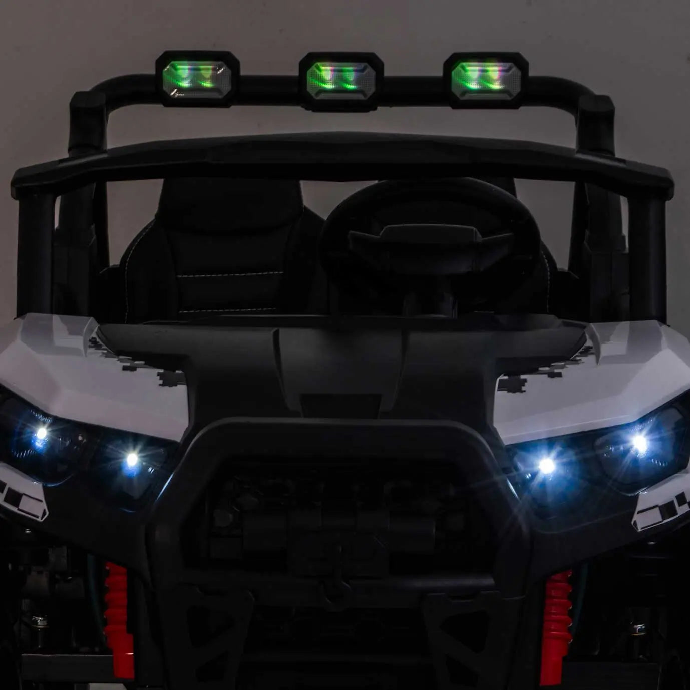 White Trail Rider 24V 4WD kids electric ride-on UTV with LED headlights illuminated, front close-up view