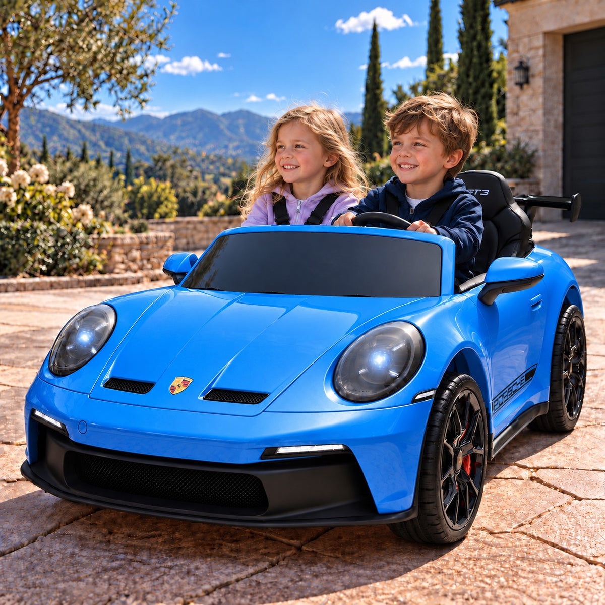 Blue Porsche 911 GT3 24V Kids 2 Seater Ride-On Car, Boy and Girl Driving on a Villa Driveway