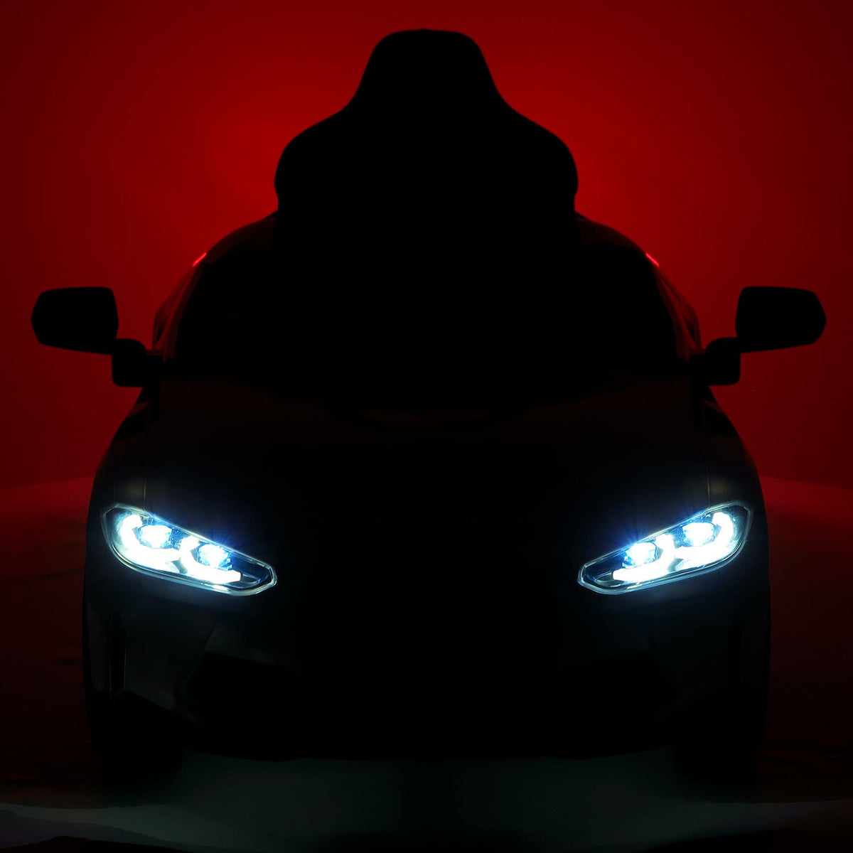 BMW M4 12V Kids Ride-On Car Front in the Dark with LED Headlights On