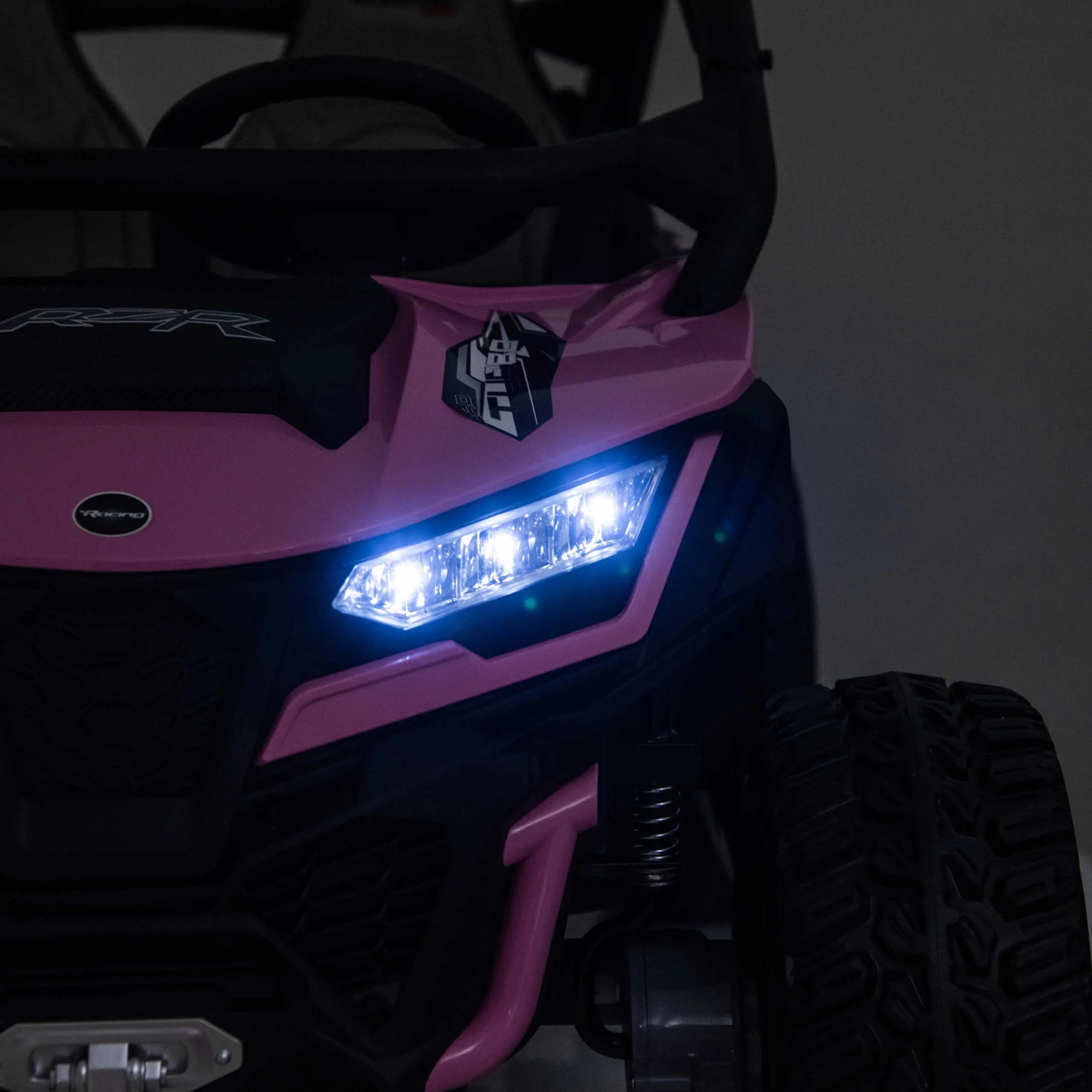 Pink Trail Runner 24V 4WD kids electric ride-on UTV with LED headlights illuminated, front close-up view-2