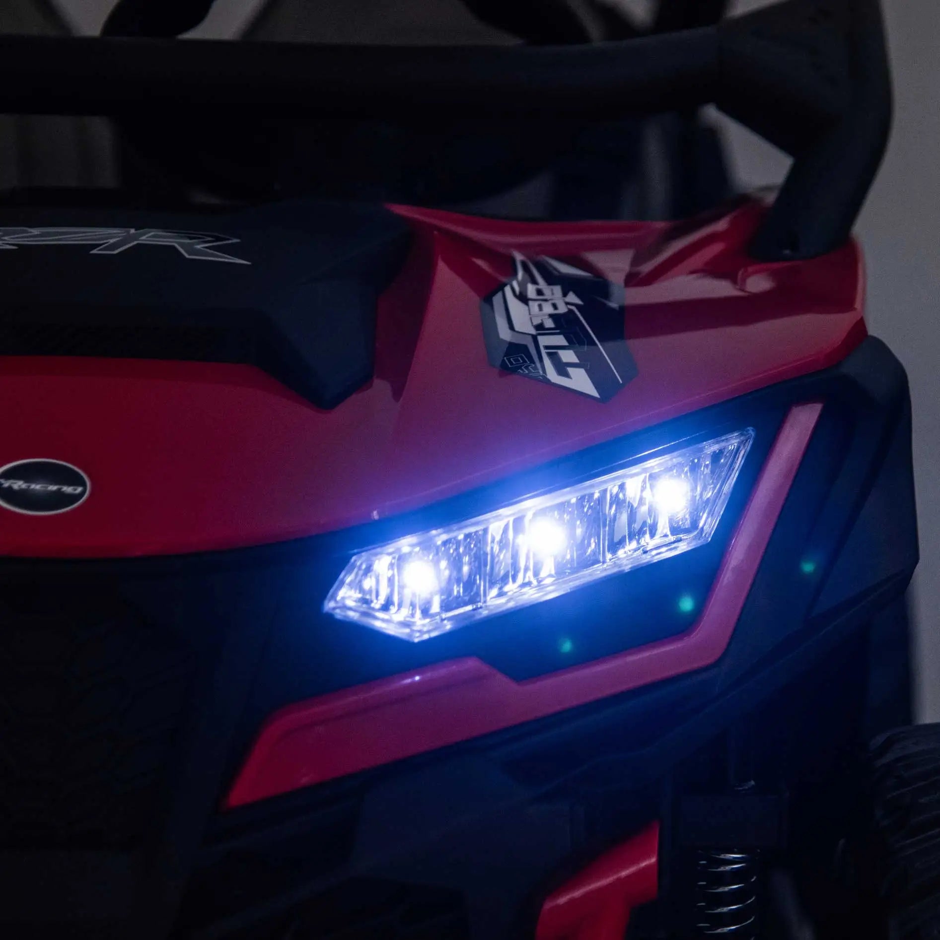 Red Trail Runner 24V 4WD kids electric ride-on UTV with LED headlights illuminated, front close-up view-2