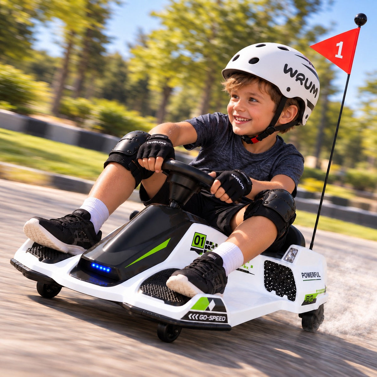 White 360° Drift Glider 24V Electric Drift Kart for Kids – Young Boy in a Helmet Drifting the Kids Go Kart on a Paved Park Track