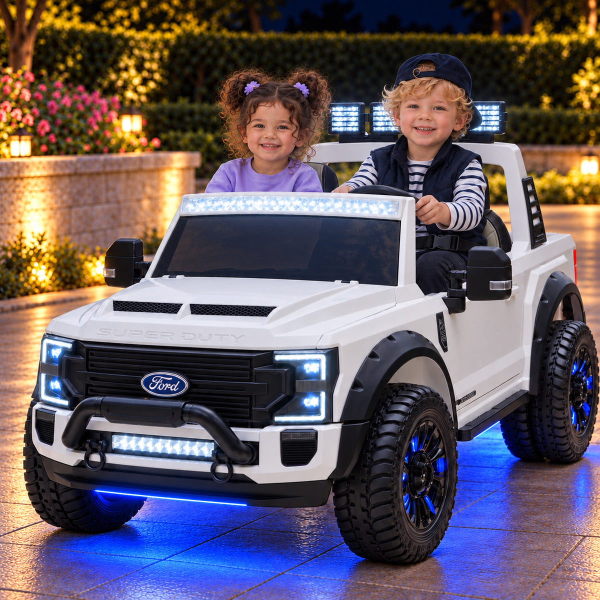 White Ford F450 24V Kids Ride-On Truck with LED Light Bars and Blue Underbody Lights, Night Lifestyle Photo